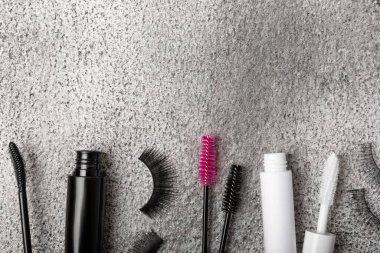 Composition with mascara and false eyelashes on a black marble background. Beauty concept. Makeup kit. Makeup. Place for text. Copy space. Close-up. FLETLEY