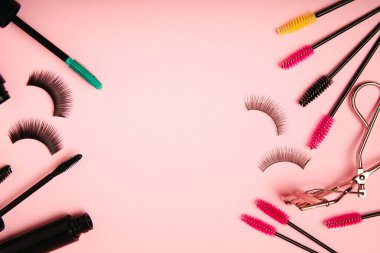 Composition with curlers, mascara and false eyelashes on a pink background. Beauty concept. Makeup kit. Makeup. Place for text. Copy space. Close-up. FLETLEY