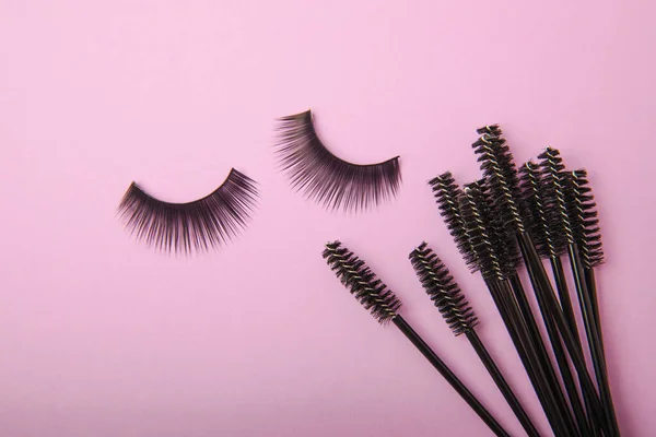 False eyelashes and an eyelash brush on a lilac background close-up. Makeup. Beauty concept. Beautiful long eyelashes in a beauty salon