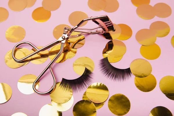 Eyelash curler, false eyelashes and mascara on a pink background. Beauty concept. Makeup. Place for text. Copy space.