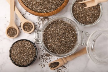 Bowl and spoon with chia seeds on a white marble table. Superfood. Proper nutrition. Diet. Healthy food. Place for text. Place to copy.