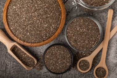 Bowl and spoon with chia seeds on a black table. Superfood. Proper nutrition. Diet. Healthy food. Place for text. Place to copy.