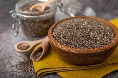 Bowl and spoon with chia seeds on a black table. Superfood. Proper nutrition. Diet. Healthy food. Place for text. Place to copy.