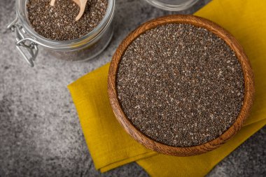 Bowl and spoon with chia seeds on a black table. Superfood. Proper nutrition. Diet. Healthy food. Place for text. Place to copy.