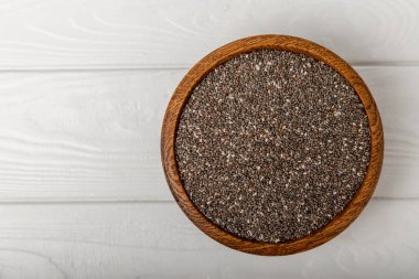 A bowl of chia seeds on a texture table. Superfood. Proper nutrition. Diet. Healthy food. Place for text. Place to copy.