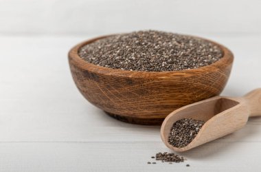 Bowl and spoon with chia seeds on a white wooden table. Superfood. Proper nutrition. Diet. Healthy food. Place for text. Place to copy.