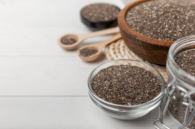Bowl and spoon with chia seeds on a white wooden table. Superfood. Proper nutrition. Diet. Healthy food. Place for text. Place to copy.