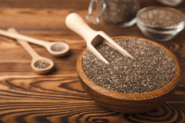 Chia seeds in a bowl and spoons on a brown textural background. Superfood. Proper nutrition. Diet. Healthy food. Place for text. Place to copy.