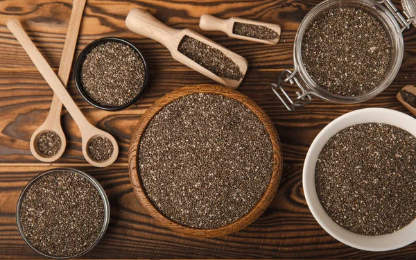 Chia seeds in a bowl and spoons on a brown textural background. Superfood. Proper nutrition. Diet. Healthy food. Place for text. Place to copy.