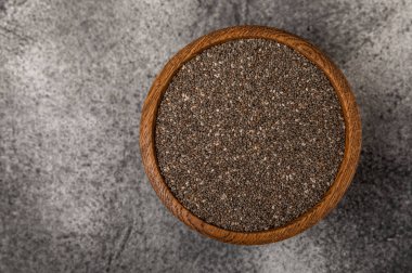 Chia seeds in a bowl on a textured black background. Diet food. Superfood. Healthy food. Space for text, copy space