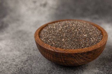 Chia seeds in a bowl on a textured black background. Diet food. Superfood. Healthy food. Space for text, copy space