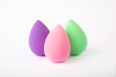 Güzellik karıştırıcısı beyaz arkaplanda izole edilmiş. Kozmetik için parlak süngerler. Makyaj ürünleri. Güzellik konsepti. ÇEVİRİ.