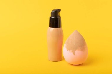 Beauty blender and tannal cream, concealer on a yellow background. Bright sponges for cosmetics. Makeup products. Beauty concept. Place for text. Place to copy. flat lay