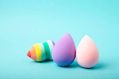 Beauty blender on blue background.Bright sponges for make-up cosmetics. Makeup products. Beauty concept. Place for text. Space for copy. Flat lay
