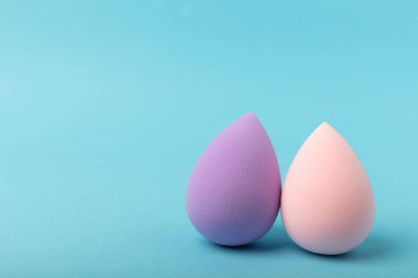 Beauty blender on blue background.Bright sponges for make-up cosmetics. Makeup products. Beauty concept. Place for text. Space for copy. Flat lay
