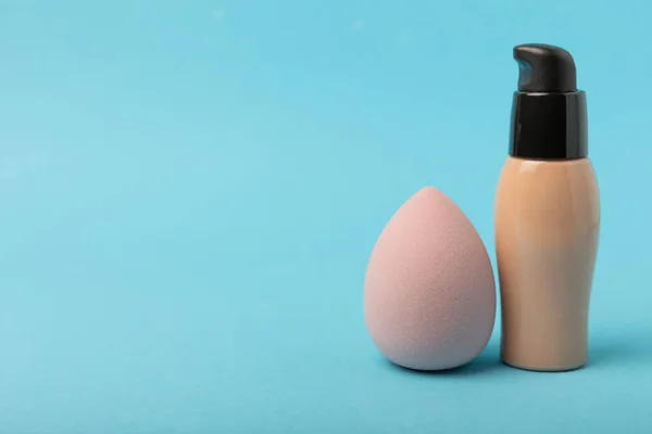 Beauty blender and tannal cream, concealer on a blue background. Bright sponges for cosmetics. Makeup products. Beauty concept. Place for text. Place to copy. flat lay
