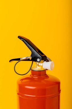 Fire extinguisher on a yellow background. Fire protection, home fire extinguisher. home security concept. Place for text. Copy space.