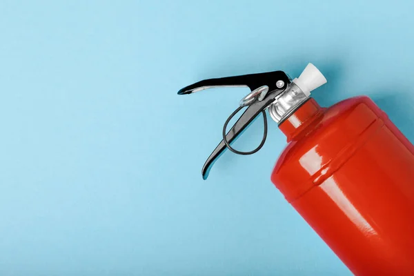 Fire extinguisher on the background of a blue wall. Fire protection, home fire extinguisher. home security concept. Place for text. Copy space.