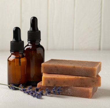 Essential oils, handmade soap and lavender flowers on a white textural background. Spa concept. Relaxation and relaxation. Body and skin care. Place for text. Place to copy.