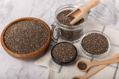 Chia seeds in a bowl and spoons on white marble. Superfood. Antioxidant. Healthy food. Proper nutrition. Diet concept. Place for text. Place to copy.
