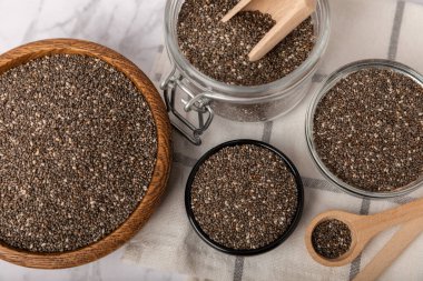 Chia seeds in a bowl and spoons on white marble. Superfood. Antioxidant. Healthy food. Proper nutrition. Diet concept. Place for text. Place to copy.