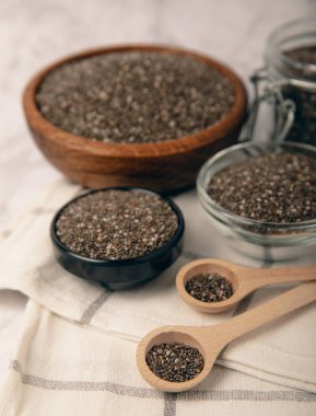 Chia seeds in a bowl and spoons on white marble. Superfood. Antioxidant. Healthy food. Proper nutrition. Diet concept. Place for text. Place to copy.
