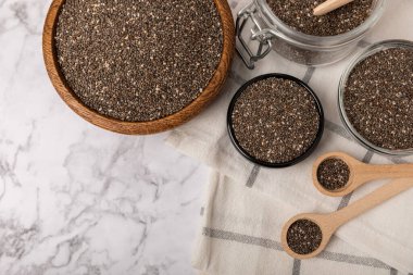 Chia seeds in a bowl and spoons on white marble. Superfood. Antioxidant. Healthy food. Proper nutrition. Diet concept. Place for text. Place to copy.