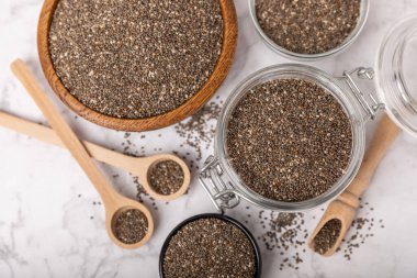 Chia seeds in a bowl and spoons on white marble. Superfood. Antioxidant. Healthy food. Proper nutrition. Diet concept. Place for text. Place to copy.