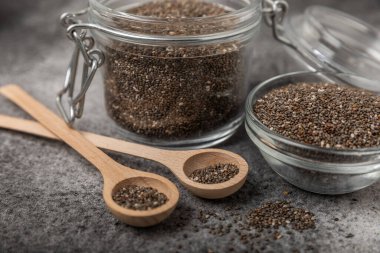 Chia seeds in a bowl and spoons on black marble. Superfood. Antioxidant. Healthy food. Proper nutrition. Diet concept. Place for text. Place to copy.
