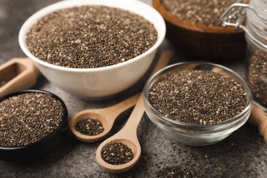 Chia seeds in a bowl and spoons on black marble. Superfood. Antioxidant. Healthy food. Proper nutrition. Diet concept. Place for text. Place to copy.
