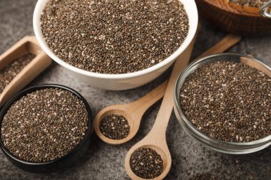 Chia seeds in a bowl and spoons on black marble. Superfood. Antioxidant. Healthy food. Proper nutrition. Diet concept. Place for text. Place to copy.