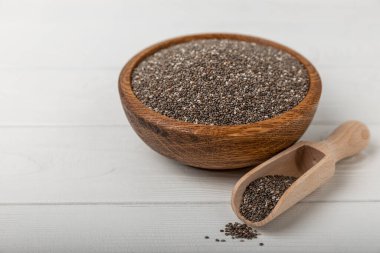 Chia seeds in jar and spoons on white texture wood. Superfood. Antioxidant. Healthy food. Proper nutrition. Diet concept. Place for text. Place to copy. selective focus.