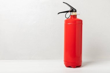 Fire extinguisher on a white texture background. Fire protection, home fire extinguisher. home security concept. Place for text. Copy space.
