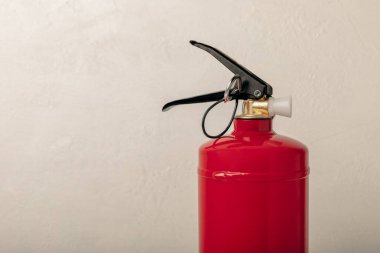 Fire extinguisher on a white texture background. Fire protection, home fire extinguisher. home security concept. Place for text. Copy space.