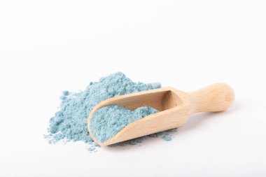 Blue spirulina powder in wooden spoon isolated on white background. Natural vegan superfood. Food supplement. Phycocyanin extract.