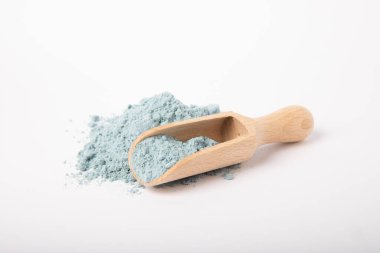 Blue spirulina powder in wooden spoon isolated on white background. Natural vegan superfood. Food supplement. Phycocyanin extract.