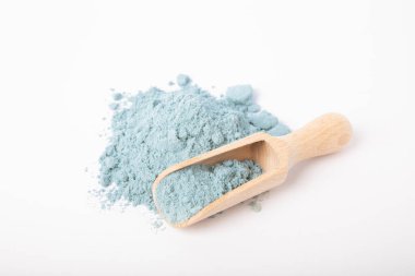 Blue spirulina powder in wooden spoon isolated on white background. Natural vegan superfood. Food supplement. Phycocyanin extract.