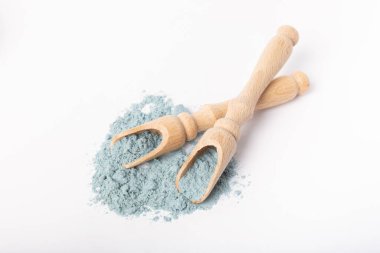 Blue spirulina powder in wooden spoon isolated on white background. Natural vegan superfood. Food supplement. Phycocyanin extract.