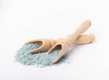 Blue spirulina powder in wooden spoon isolated on white background. Natural vegan superfood. Food supplement. Phycocyanin extract.