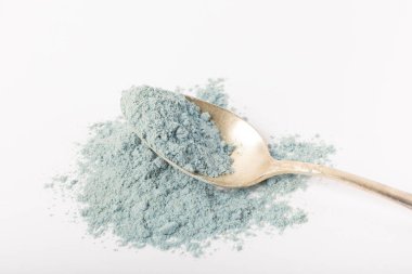 Blue spirulina powder in spoon isolated on white background. Natural vegan superfood. Food supplement. Phycocyanin extract.