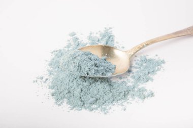 Blue spirulina powder in spoon isolated on white background. Natural vegan superfood. Food supplement. Phycocyanin extract.