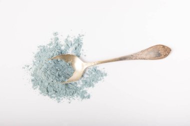 Blue spirulina powder in spoon isolated on white background. Natural vegan superfood. Food supplement. Phycocyanin extract.