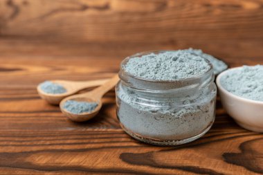 Blue Spirulina algae powder on brown texture background. Diet and detox concept.Natural vegan superfood. Food supplement. Copy space. Place for text.