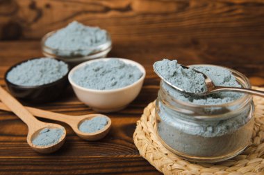 Blue Spirulina algae powder on brown texture background. Diet and detox concept.Natural vegan superfood. Food supplement. Copy space. Place for text.