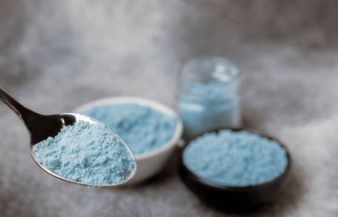 Blue Spirulina algae powder on black marble background. Diet and detox concept.Natural vegan superfood. Food supplement. Copy space. Place for text.