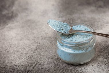 Blue Spirulina algae powder on black marble background. Diet and detox concept.Natural vegan superfood. Food supplement. Copy space. Place for text.