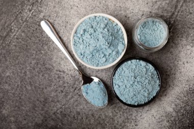 Blue Spirulina algae powder on black marble background. Diet and detox concept.Natural vegan superfood. Food supplement. Copy space. Place for text.