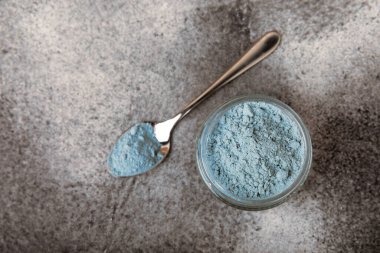Blue Spirulina algae powder on black marble background. Diet and detox concept.Natural vegan superfood. Food supplement. Copy space. Place for text.