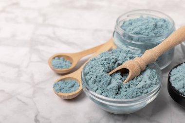 Blue Spirulina algae powder on white marble background. Diet and detox concept.Natural vegan superfood. Food supplement. Copy space. Place for text.