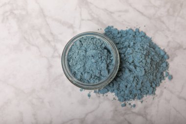 Blue Spirulina algae powder on white marble background. Diet and detox concept.Natural vegan superfood. Food supplement. Copy space. Place for text.